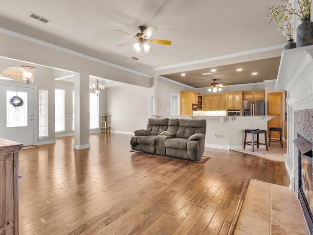 3300 S Bay Breeze Ln, Fort Worth, TX 76179 - living room with ceiling fan, light wood-type flooring, a glass covered fireplace, ornamental molding, and a chandelier