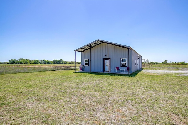 view of outdoor structure with a rural view and fence