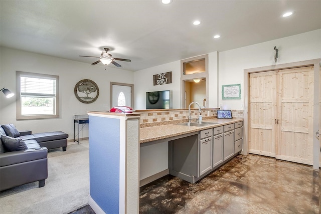 kitchen with a ceiling fan, a sink, open floor plan, a peninsula, and recessed lighting