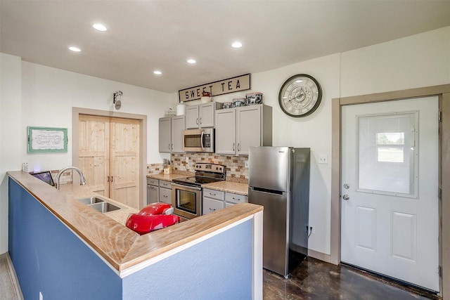 kitchen featuring recessed lighting, decorative backsplash, stainless steel appliances, and a sink