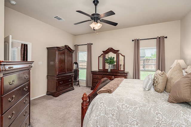 bedroom featuring baseboards, a ceiling fan, visible vents, and light colored carpet
