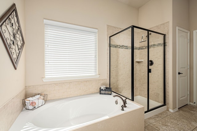 full bathroom with a shower stall and a bath