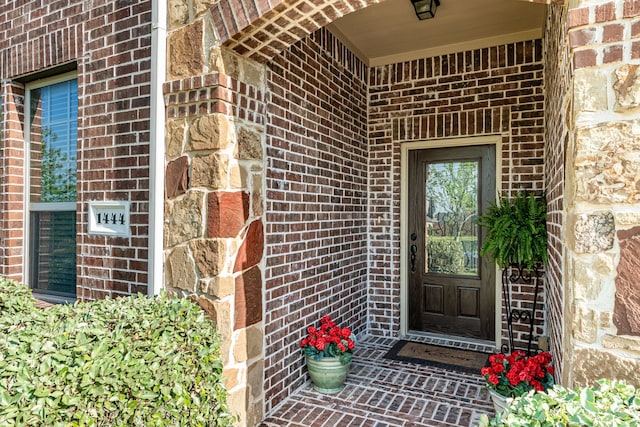 entrance to property featuring brick siding