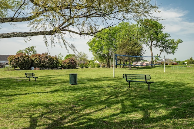view of property's community with volleyball court and a lawn