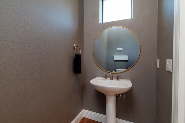 bathroom with wood finished floors and baseboards