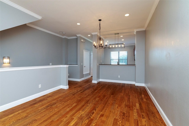 unfurnished room with baseboards, ornamental molding, wood finished floors, and a chandelier