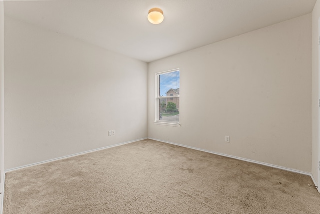 carpeted empty room with baseboards