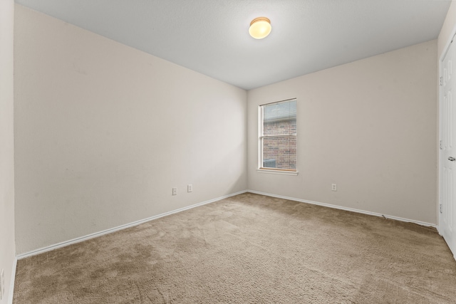 unfurnished room featuring carpet floors and baseboards