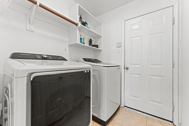 laundry area with washing machine and clothes dryer, laundry area, and light tile patterned floors