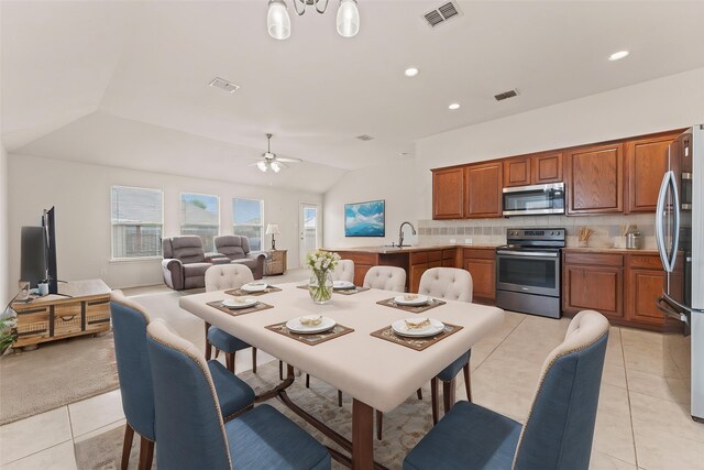 dining room featuring visible vents, a ceiling fan, light tile patterned floors, and vaulted ceiling