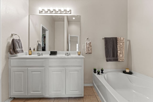 full bathroom featuring double vanity, tile patterned floors, a sink, and a bath