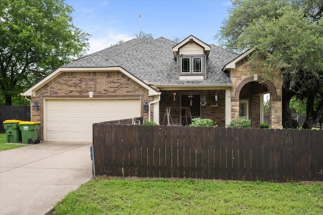 view of front of house with a garage, fence private yard, driveway, and brick siding