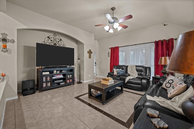 living room featuring tile patterned flooring, a ceiling fan, baseboards, and vaulted ceiling
