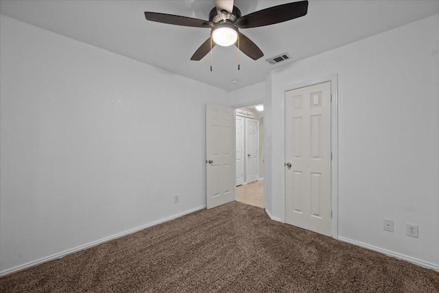 unfurnished bedroom with carpet flooring, a ceiling fan, baseboards, and visible vents