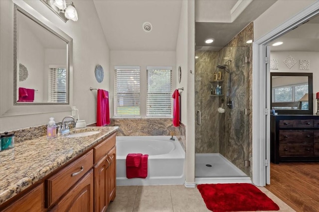 bathroom with vanity, a garden tub, vaulted ceiling, and a shower stall