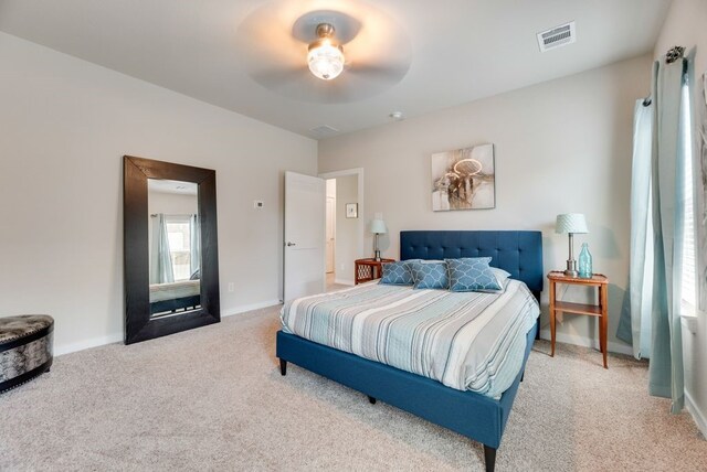 carpeted bedroom with ceiling fan, baseboards, and visible vents