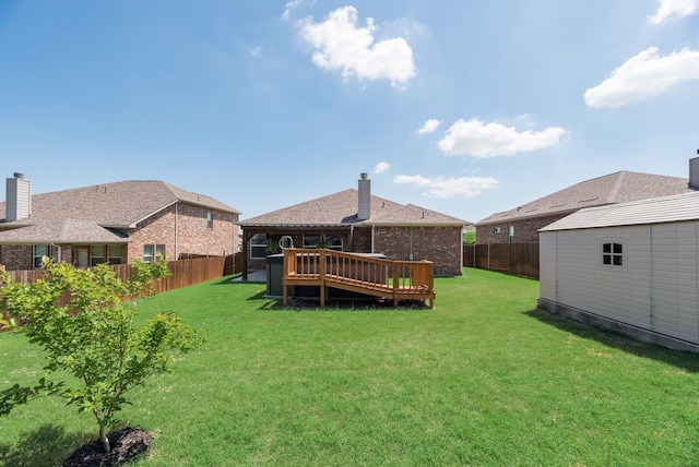 view of yard featuring a wooden deck, a shed, a fenced backyard, and an outdoor structure