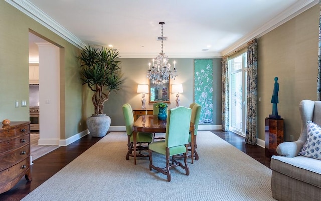 dining room featuring crown molding, wood finished floors, an inviting chandelier, baseboards, and visible vents