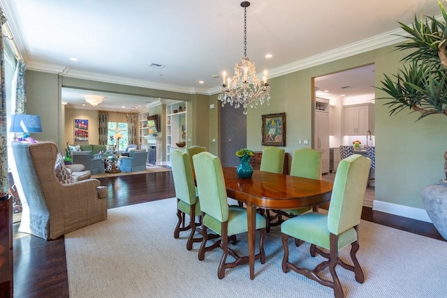 dining area featuring wood finished floors, a chandelier, ornamental molding, visible vents, and recessed lighting