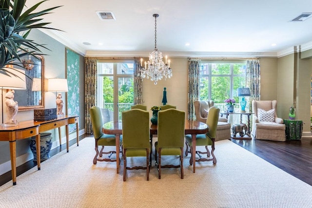 dining area with plenty of natural light, visible vents, crown molding, and a notable chandelier