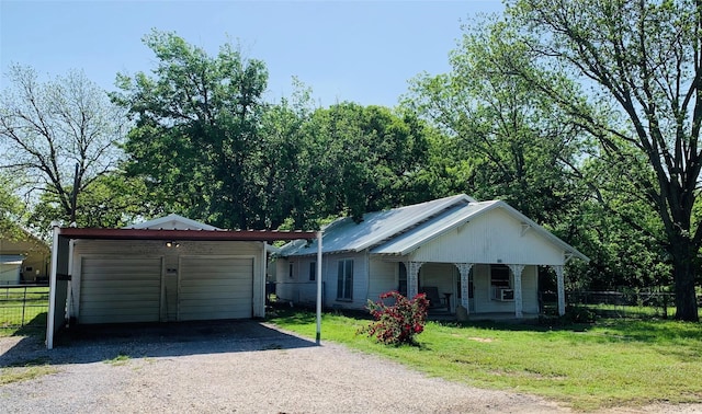 single story home with gravel driveway, fence, a front lawn, a porch, and a garage