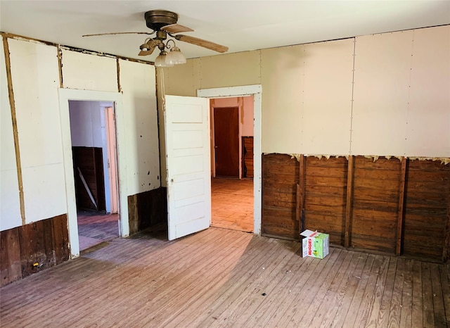 empty room with light wood-type flooring and ceiling fan