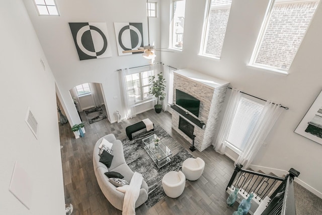 2061 Miramar Dr, Little Elm, TX 75068 - living room featuring arched walkways, a glass covered fireplace, a towering ceiling, and visible vents