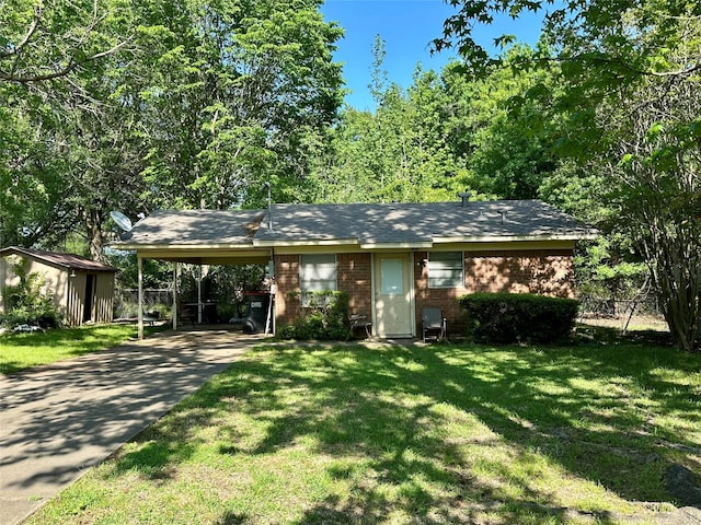 view of front of house with an attached carport, driveway, fence, brick siding, and a front yard