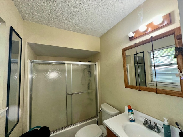full bath with enclosed tub / shower combo, toilet, vanity, and a textured ceiling
