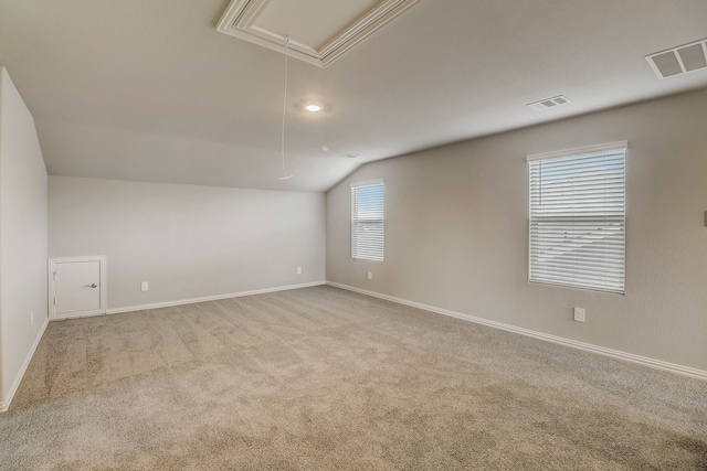 interior space featuring attic access, carpet floors, vaulted ceiling, and visible vents