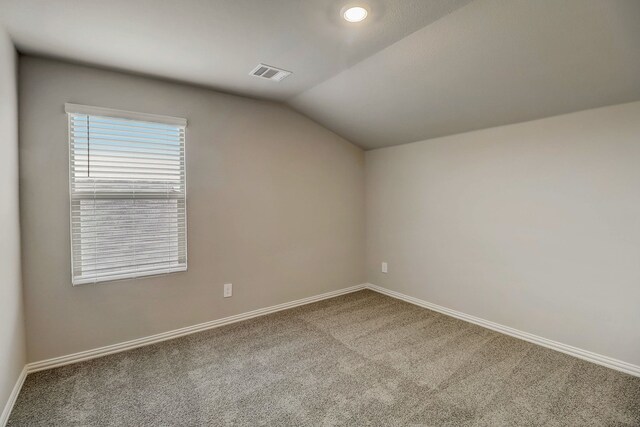 additional living space featuring lofted ceiling, baseboards, visible vents, and carpet