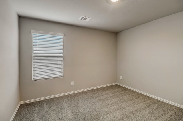 carpeted spare room featuring baseboards and visible vents