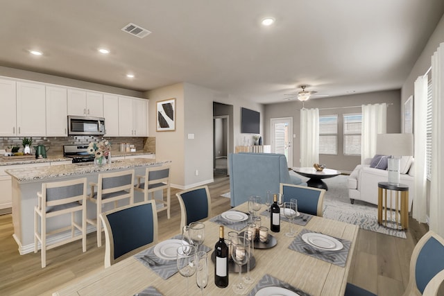 dining space with recessed lighting, visible vents, light wood finished floors, and ceiling fan