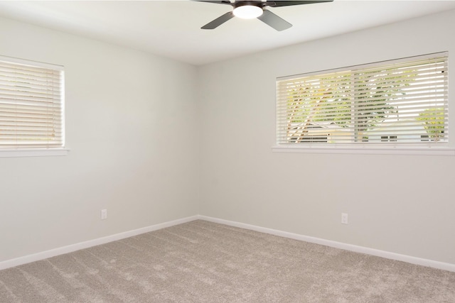 unfurnished room featuring baseboards, a ceiling fan, a wealth of natural light, and light colored carpet