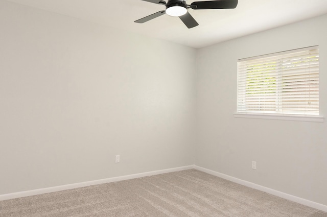 spare room featuring baseboards, ceiling fan, and light colored carpet