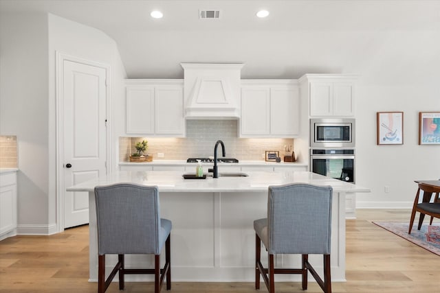 1503 Evening Primrose Dr, Mansfield, TX 76063 - kitchen with stainless steel appliances, a sink, a breakfast bar area, tasteful backsplash, and recessed lighting