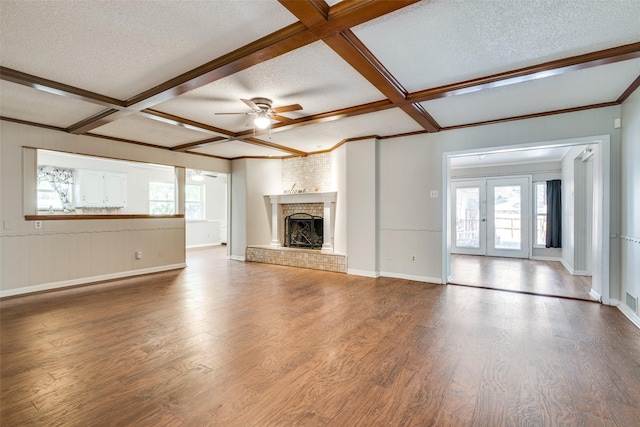 unfurnished living room with a ceiling fan, wood finished floors, a textured ceiling, and a fireplace