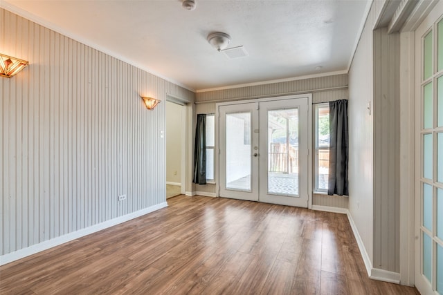 doorway to outside with baseboards, french doors, wood finished floors, and ornamental molding