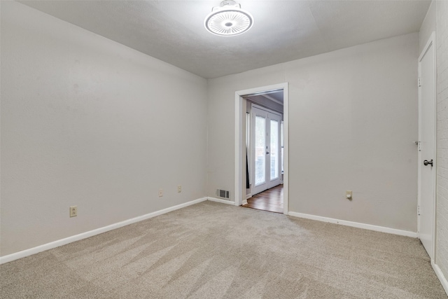 unfurnished room featuring carpet, visible vents, and baseboards