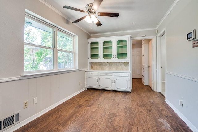 interior space with dark wood-type flooring, visible vents, crown molding, and a ceiling fan