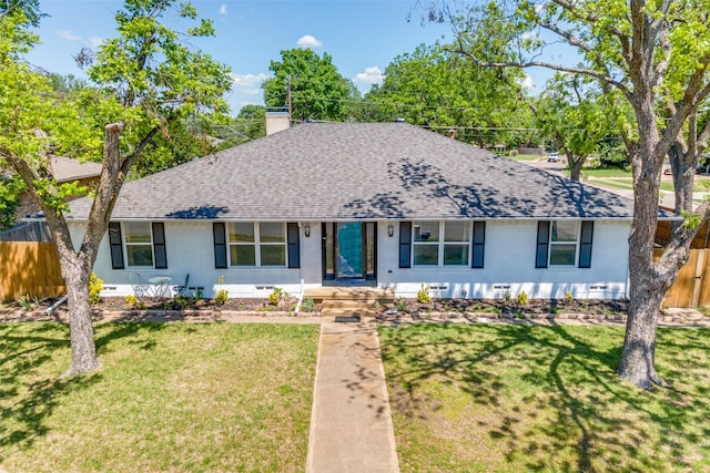 ranch-style home with a front lawn, fence, and a shingled roof