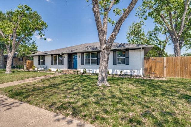 ranch-style house with fence, brick siding, and a front yard