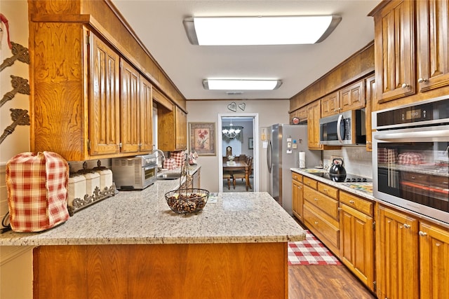 kitchen featuring brown cabinetry, a sink, and appliances with stainless steel finishes
