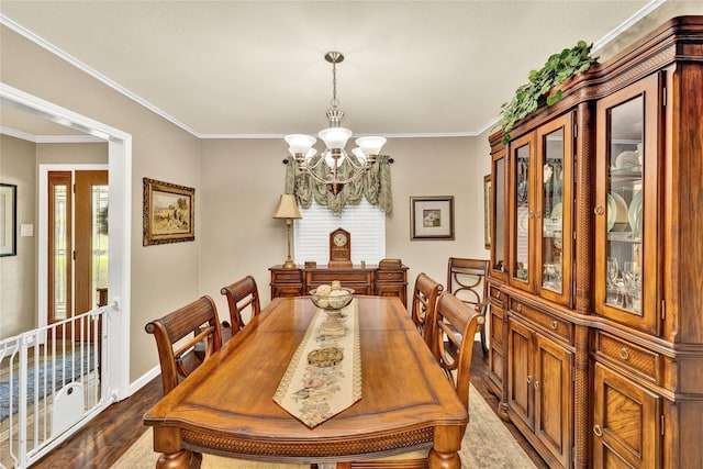 dining space featuring dark wood finished floors, baseboards, ornamental molding, and a chandelier