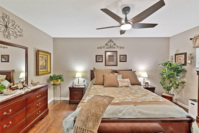 bedroom with a ceiling fan, baseboards, and dark wood-type flooring