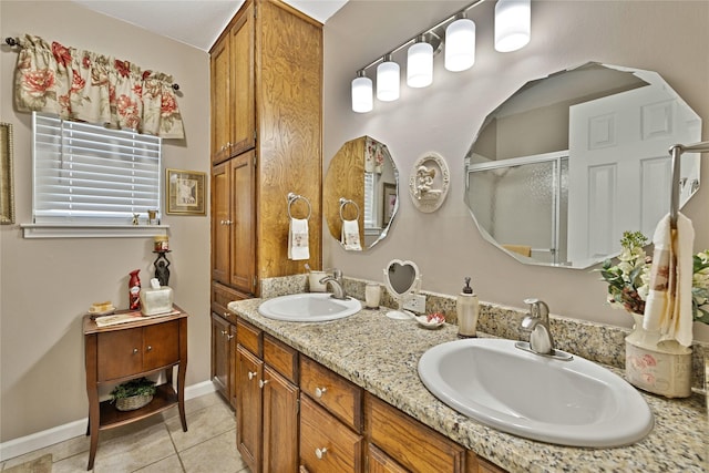 full bath with double vanity, tile patterned floors, a stall shower, and a sink