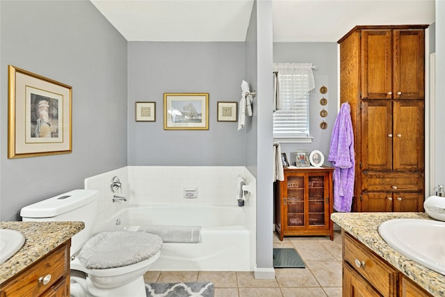 bathroom with a garden tub, tile patterned floors, vanity, and toilet