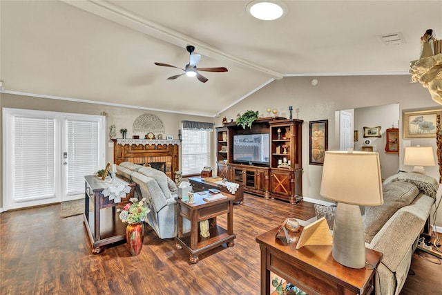 living room with vaulted ceiling with beams, a ceiling fan, wood finished floors, a brick fireplace, and ornamental molding