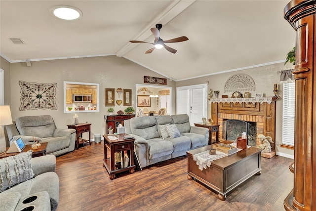living room with visible vents, vaulted ceiling with beams, dark wood-type flooring, a fireplace, and ceiling fan
