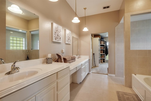 bathroom featuring a bath, vanity, tile patterned floors, and visible vents